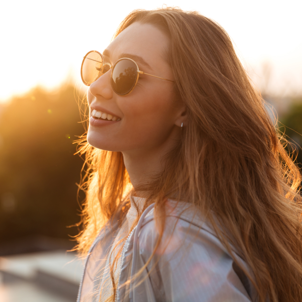 happy woman with auburn hair wearing sunglassses