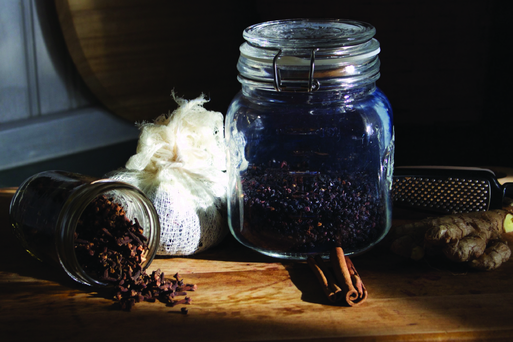 ingredients to make elderberry syrup including dried elderberries, cinnamon and ginger