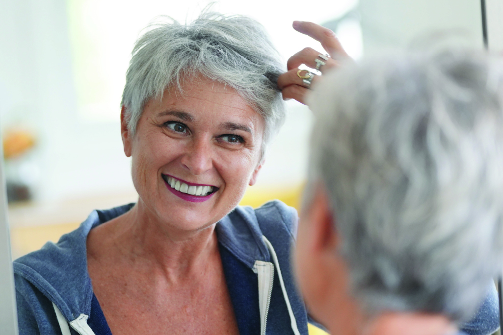senior woman smiling looking through her grey hair